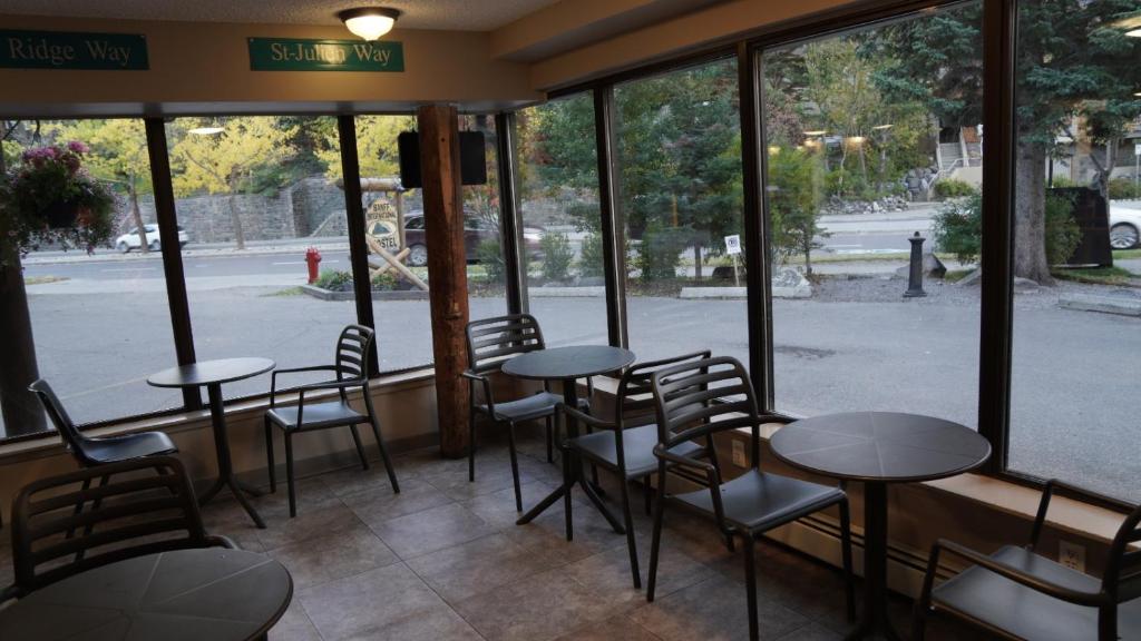 a restaurant with tables and chairs in front of a window at Banff International Hostel in Banff