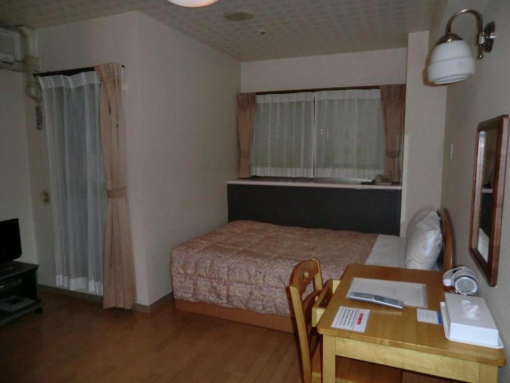 a bedroom with a bed and a desk and a table at Azu garden Nippombashi / Vacation STAY 74144 in Osaka