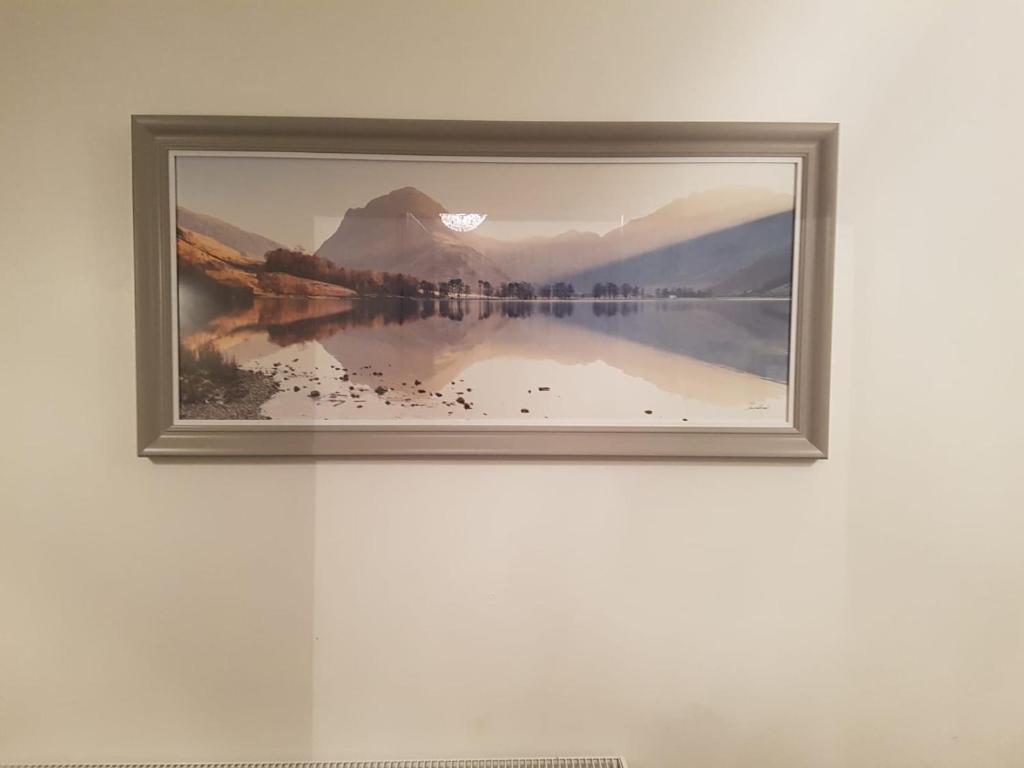 a picture of a lake in a frame on a wall at Bowness Guest House in Bowness-on-Windermere