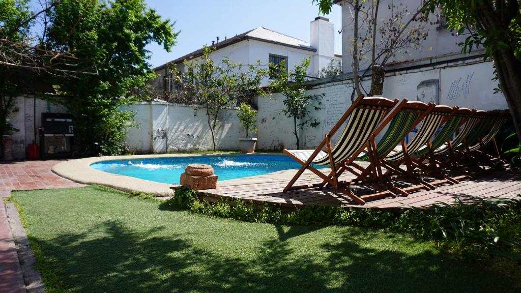 2 transats installés à côté de la piscine dans l'établissement Ventana Sur Hostal, à Santiago