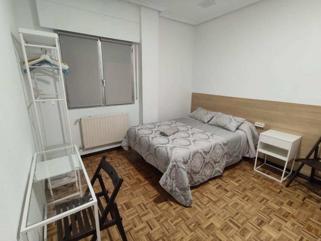 a bedroom with a bed and a table and chairs at Apartamento Cigüeña in Logroño