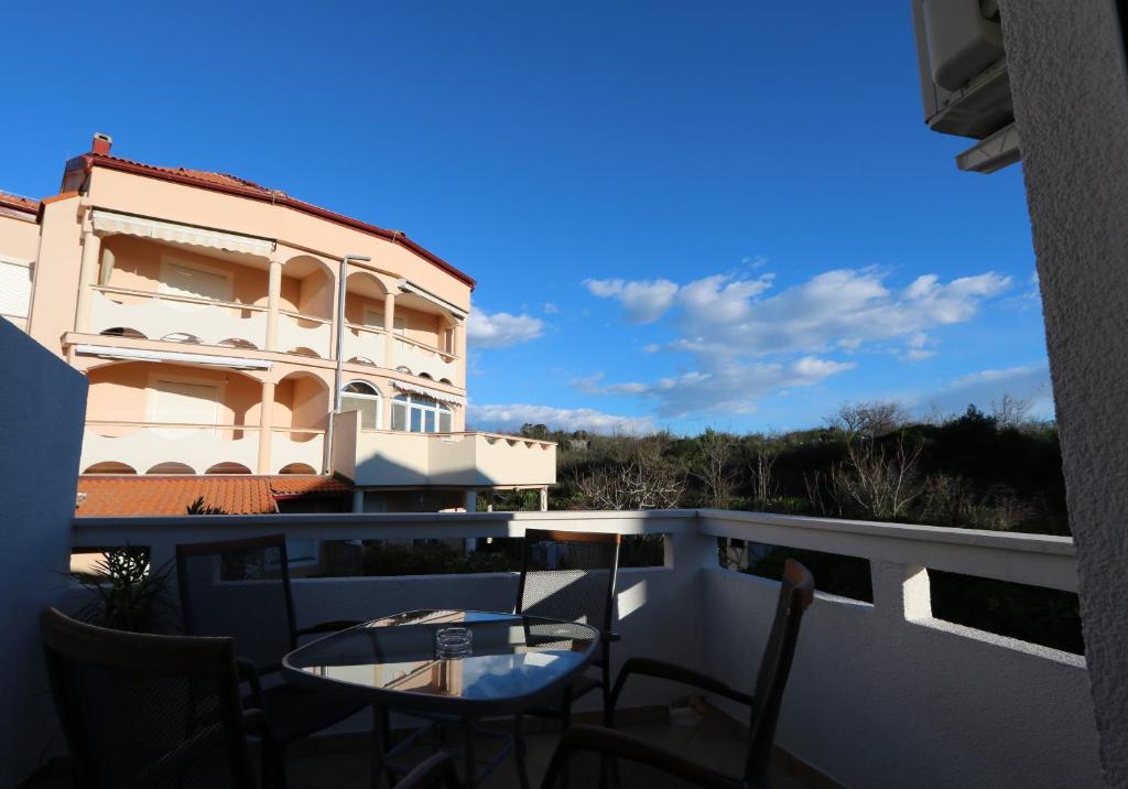 balkon z krzesłami i stołem oraz budynek w obiekcie Antodo Marija w Novalji