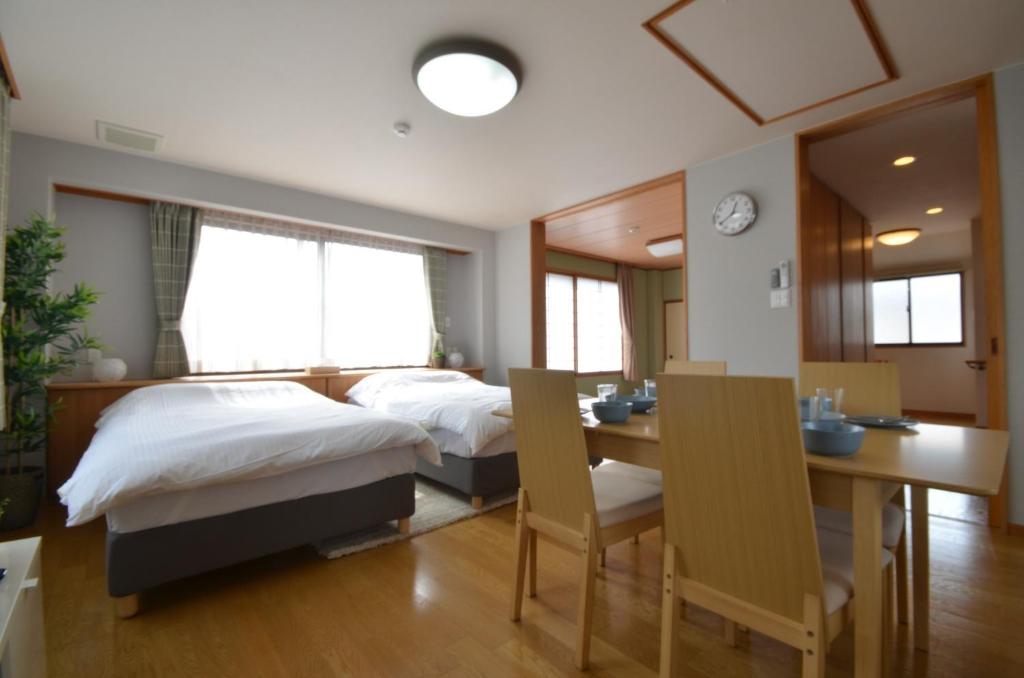 高松市にあるTakamatsu - House / Vacation STAY 38164のベッドルーム1室(ベッド2台、テーブル、椅子付)