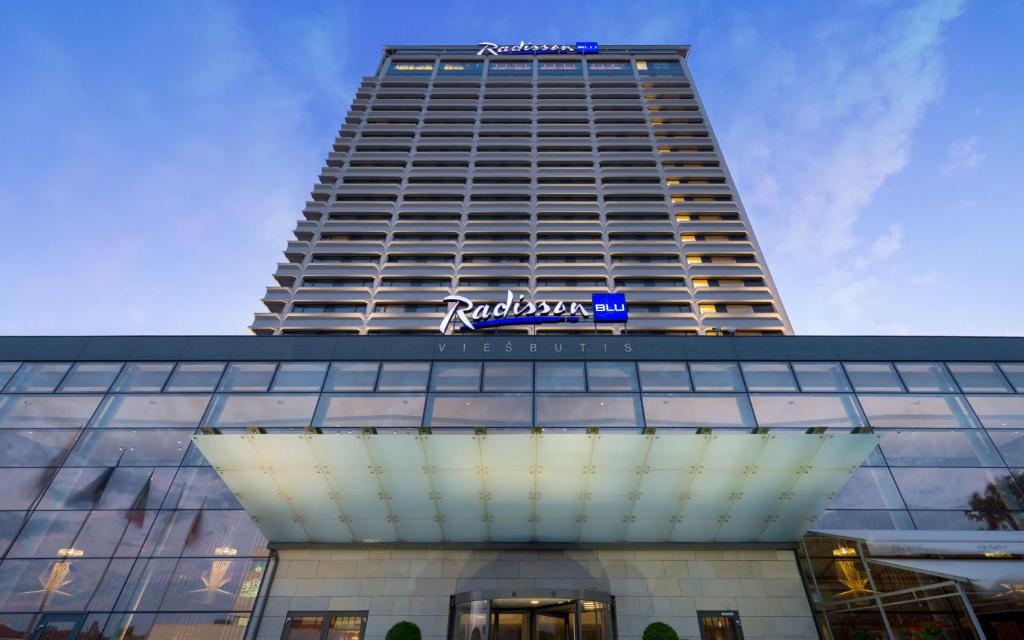 a tall building with a sign on top of it at Radisson Blu Hotel Lietuva in Vilnius