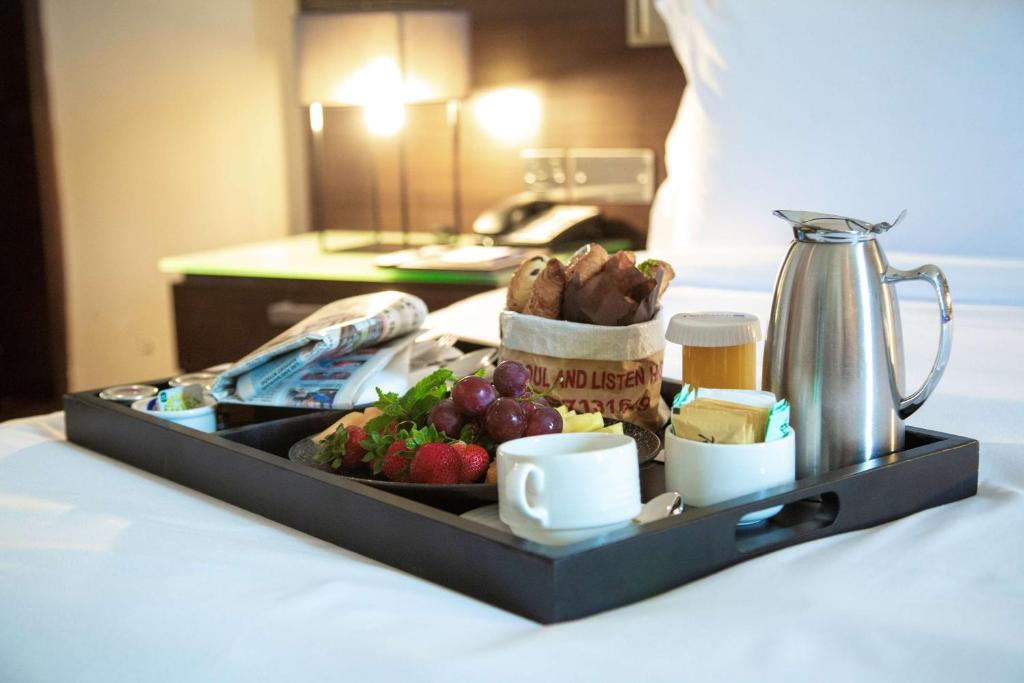 a tray of food on a table with a plate of fruit at Radisson Blu Hotel, Abu Dhabi Yas Island in Abu Dhabi