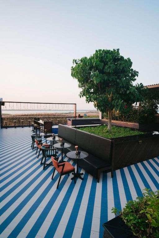 a patio with tables and chairs and a tree on a roof at Radisson Blu Hotel, Abu Dhabi Yas Island in Abu Dhabi