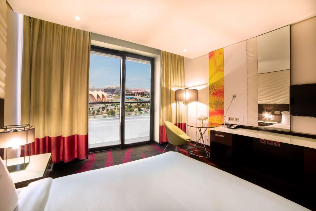 a hotel room with a bed and a large window at Radisson Blu Hotel, Abu Dhabi Yas Island in Abu Dhabi
