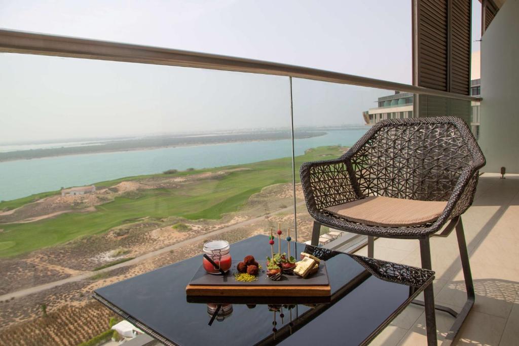 a chair and a table on a balcony with a view at Radisson Blu Hotel, Abu Dhabi Yas Island in Abu Dhabi