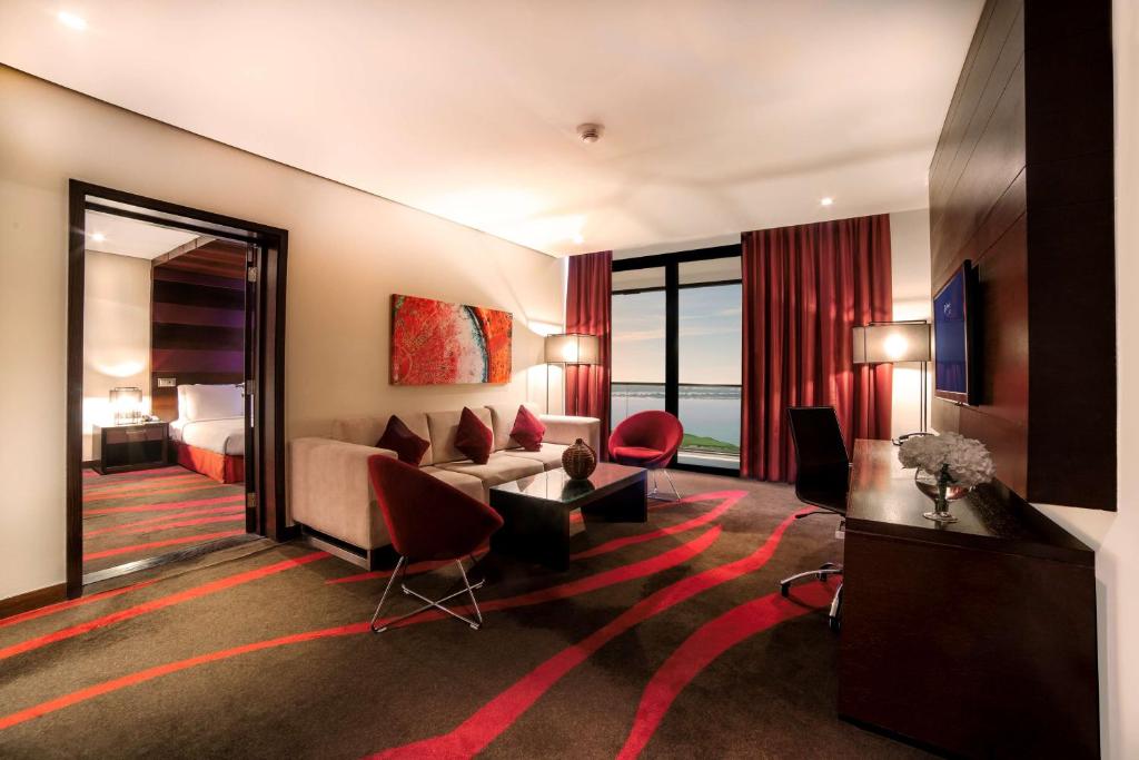 a hotel room with a couch and a bed at Radisson Blu Hotel, Abu Dhabi Yas Island in Abu Dhabi