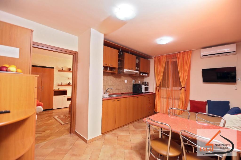 eine Küche und ein Esszimmer mit einem Tisch und Stühlen in der Unterkunft Apartament Ema Baile Felix in Baile Felix