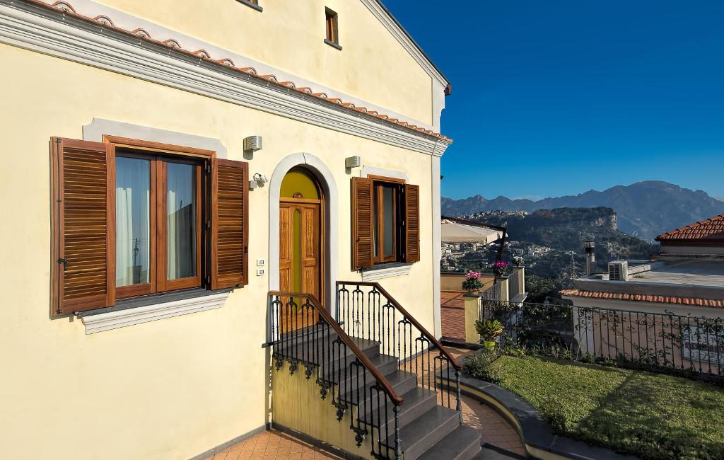 ein weißes Haus mit einer Holztür und einer Treppe in der Unterkunft Villa Maria in Amalfi