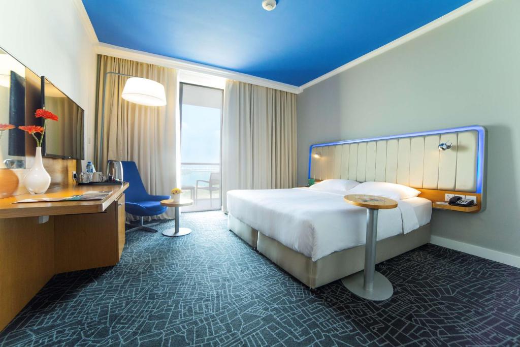 a hotel room with a bed and a desk at Park Inn by Radisson Abu Dhabi Yas Island in Abu Dhabi