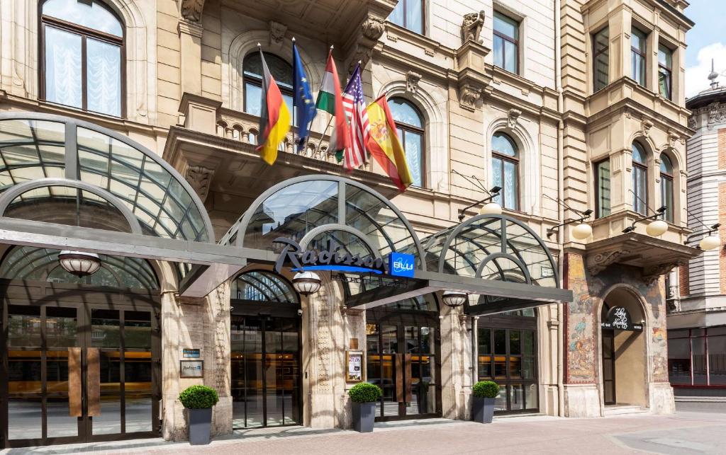 un edificio con diverse bandiere di fronte ad esso di Radisson Blu Béke Hotel, Budapest a Budapest