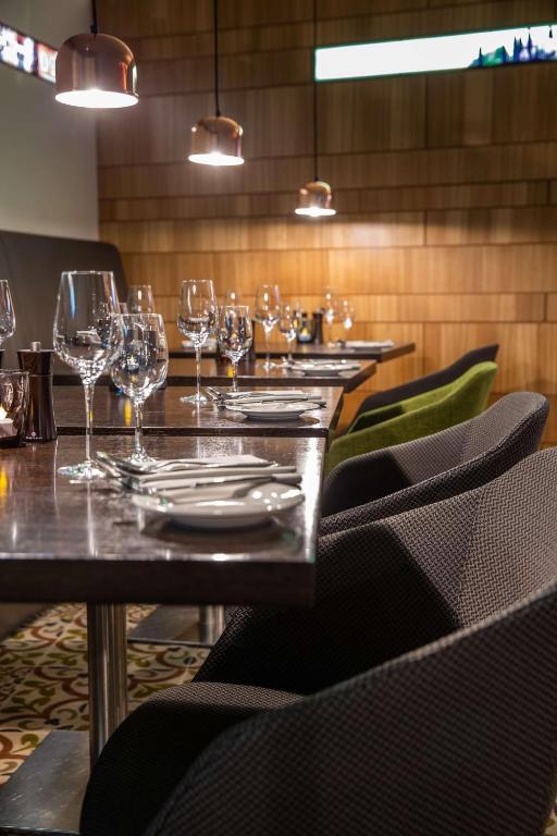 a table in a restaurant with wine glasses on it at Radisson Blu Hotel, Hamburg Airport in Hamburg
