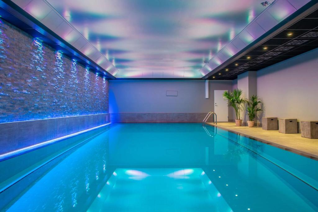 an indoor swimming pool with blue lighting at Radisson Blu Scandinavia Hotel, Oslo in Oslo