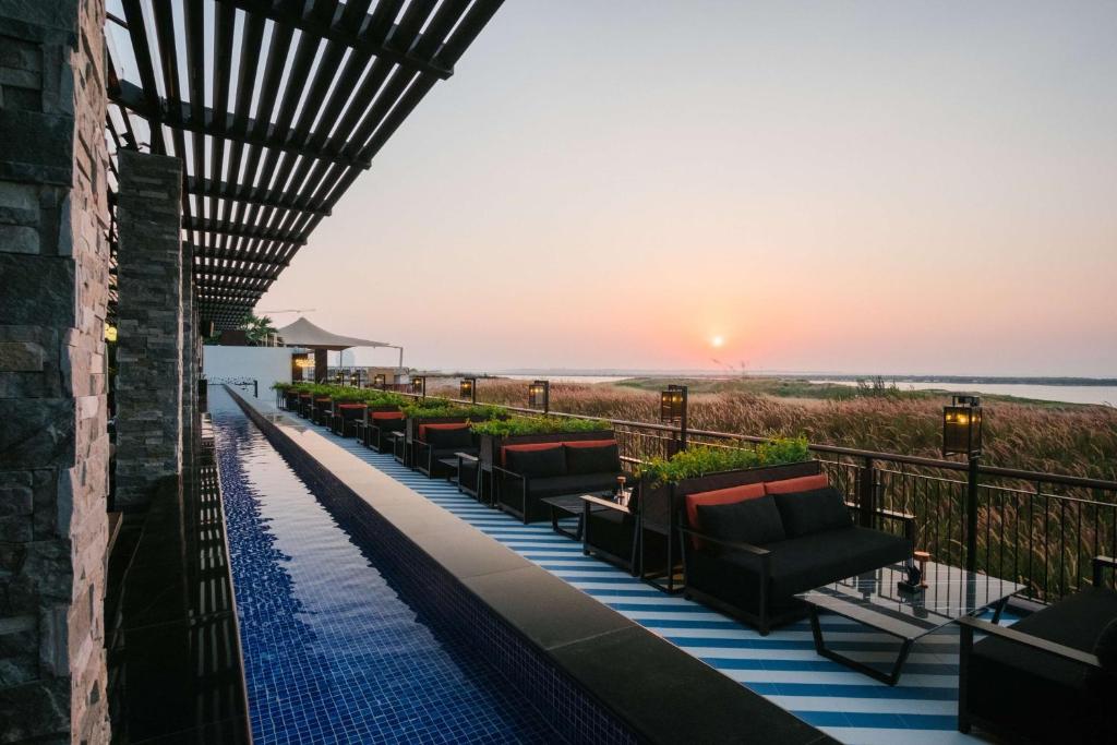 a hotel pool with chairs and a view of the beach at Radisson Blu Hotel, Abu Dhabi Yas Island in Abu Dhabi