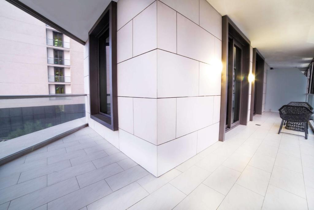 an empty hallway with white tile flooring and large windows at Radisson Blu Hotel, Abu Dhabi Yas Island in Abu Dhabi
