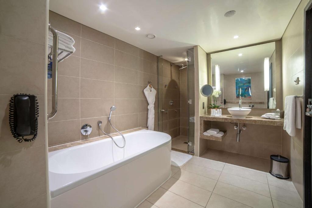 a bathroom with a bath tub and a sink at Radisson Blu Hotel, Abu Dhabi Yas Island in Abu Dhabi