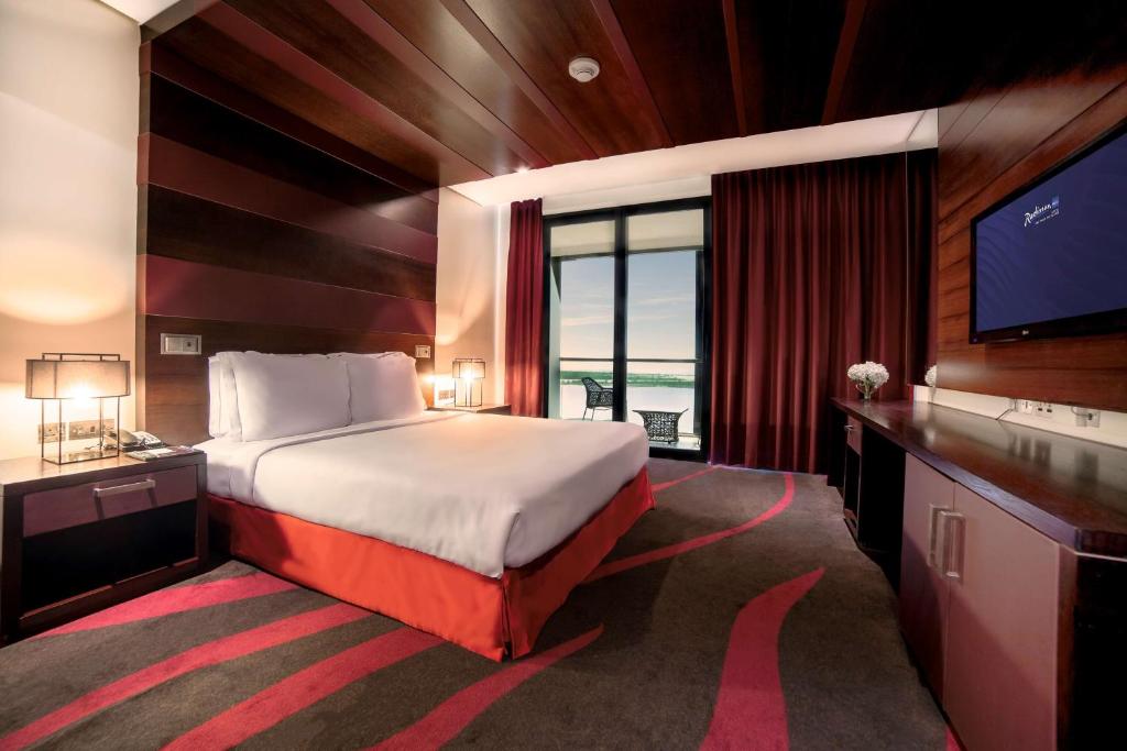 a bedroom with a large bed and a television at Radisson Blu Hotel, Abu Dhabi Yas Island in Abu Dhabi