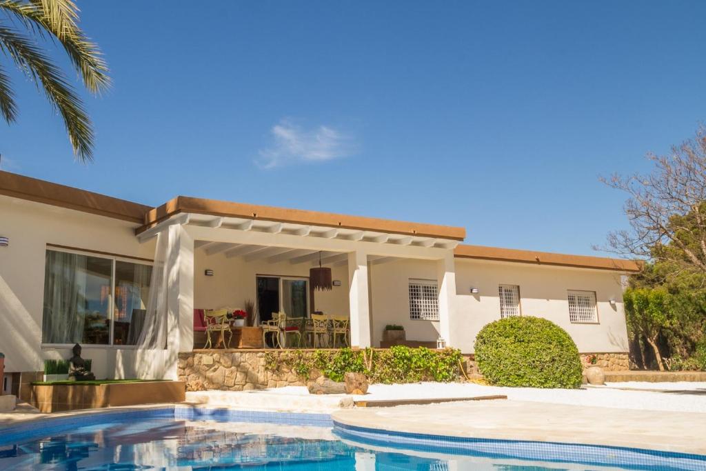 a house with a swimming pool in front of a house at Azul Rentals Villa Albir in Albir