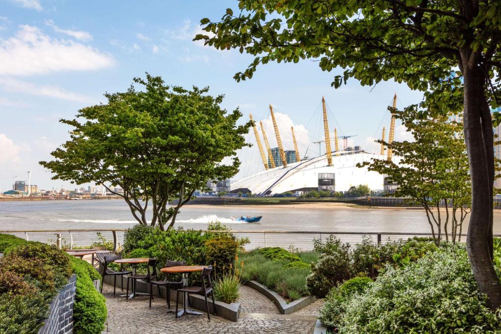 a view of a river with benches and buildings at Radisson Blu Edwardian New Providence Wharf Hotel, London in London