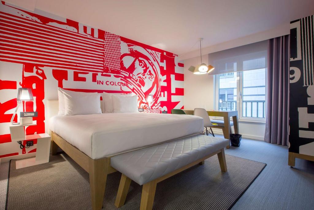 a bedroom with a white bed and white walls at Radisson RED Brussels in Brussels