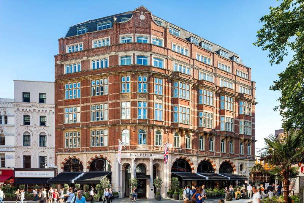 a large brick building with people walking in front of it at Radisson Blu Edwardian Hampshire Hotel, London in London