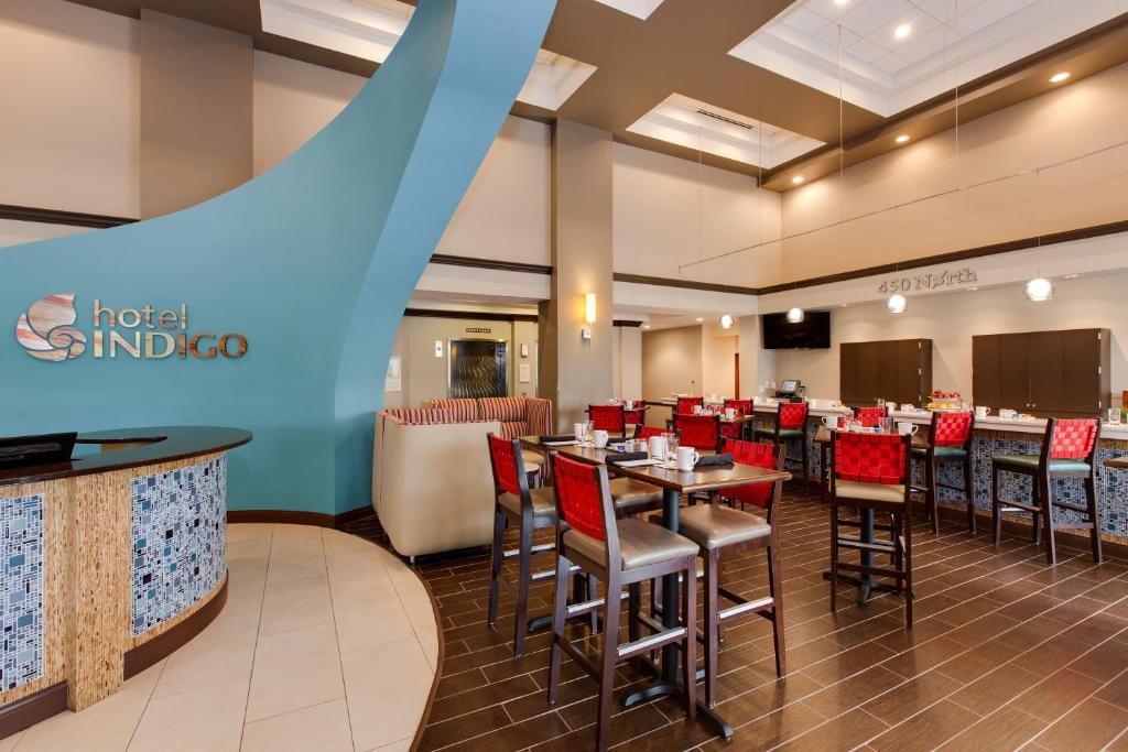 a restaurant with tables and chairs in a room at Hotel Indigo Chicago - Vernon Hills, an IHG Hotel in Vernon Hills