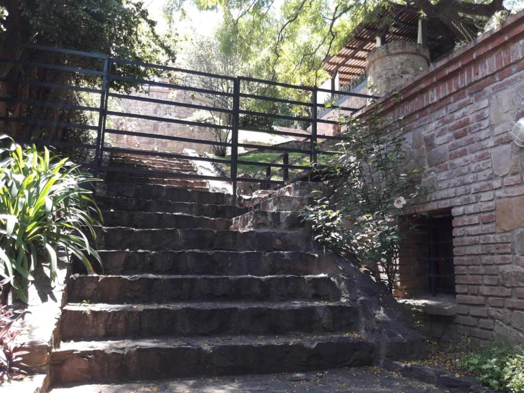 um conjunto de escadas de pedra ao lado de uma parede de tijolos em Apartamentos del Cerro em Salta