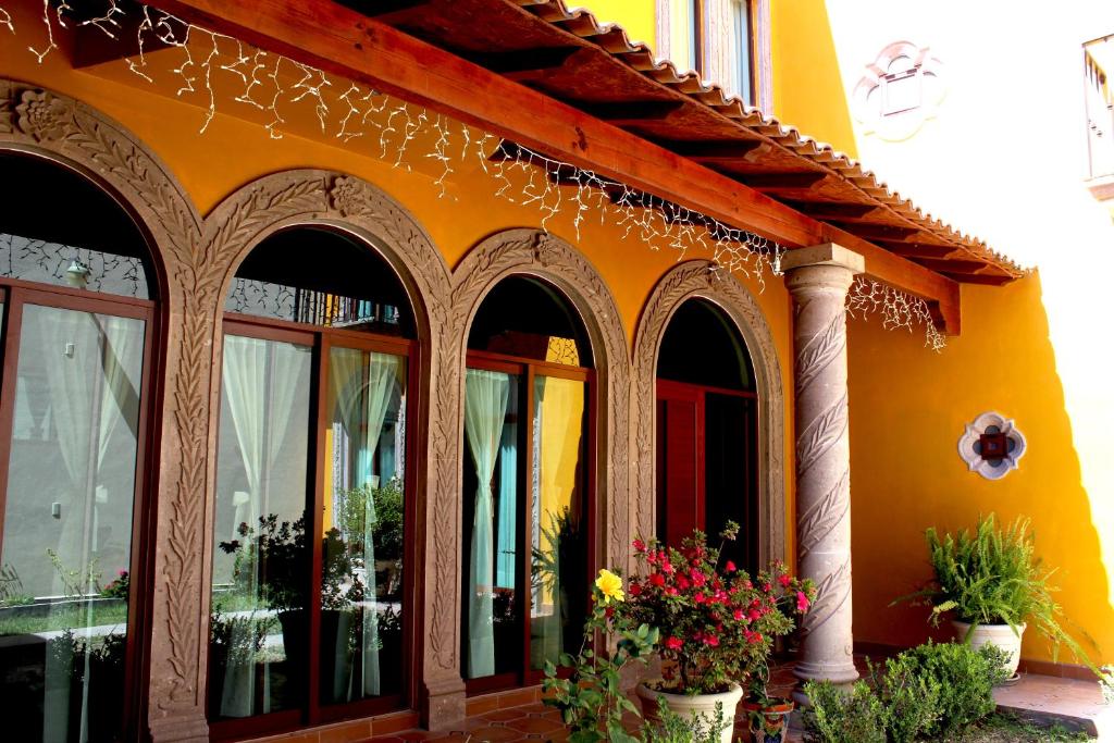 um edifício laranja com vasos de plantas à sua frente em El Molino de Allende Guest House em San Miguel de Allende