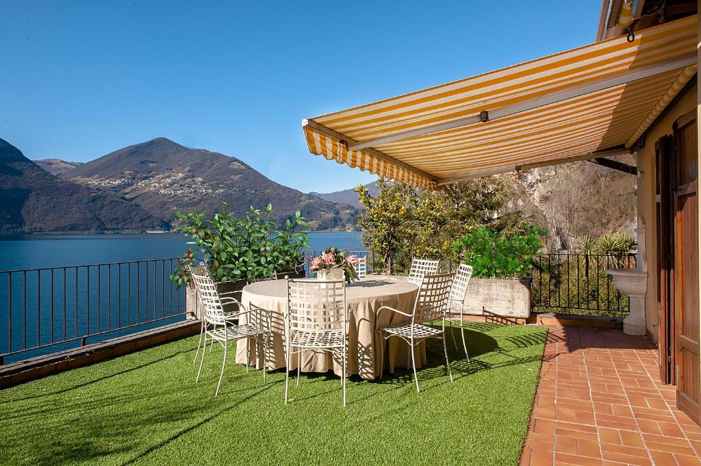 a patio with a table and chairs on the grass at The Terrace on the Lake in Marone