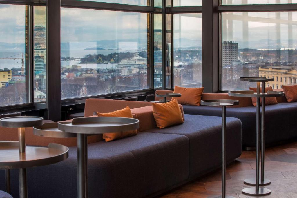 a living room filled with couches and tables at Radisson Blu Scandinavia Hotel, Oslo in Oslo