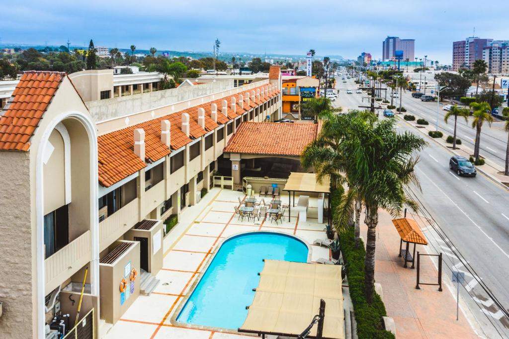 羅薩里托的住宿－Del Mar Inn Rosarito，享有带游泳池和街道的建筑的空中景致