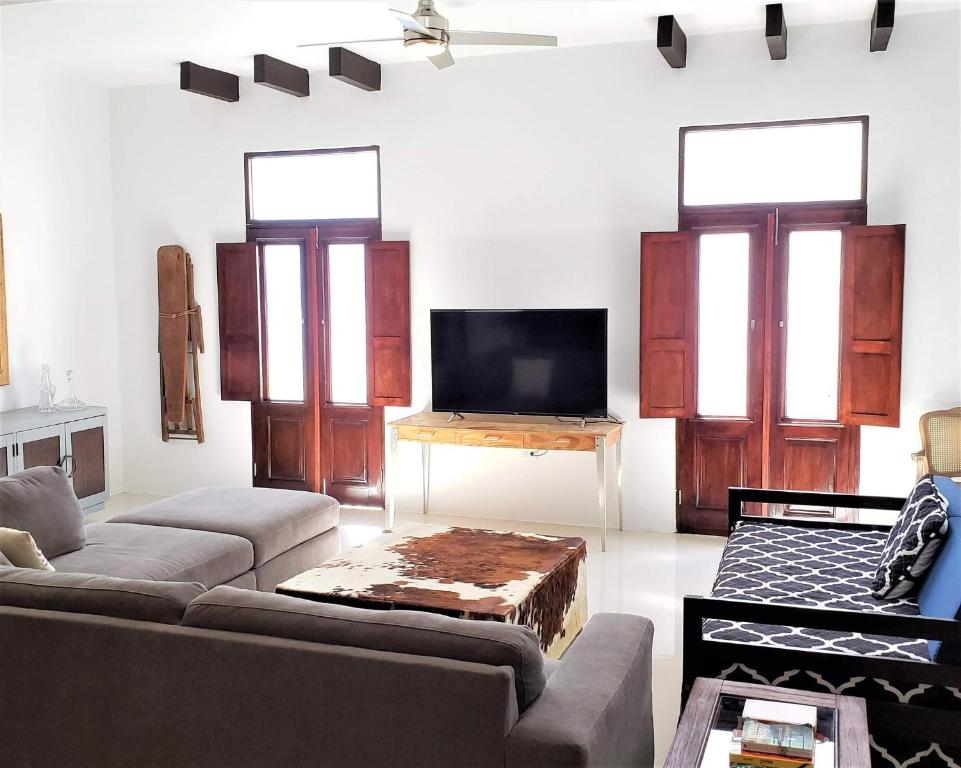 KASA The Lofts of Old San Juan 201 HUGE 2 bed 2 bath for 6 Washer Dryer في سان خوان: غرفة معيشة مع أريكة وتلفزيون