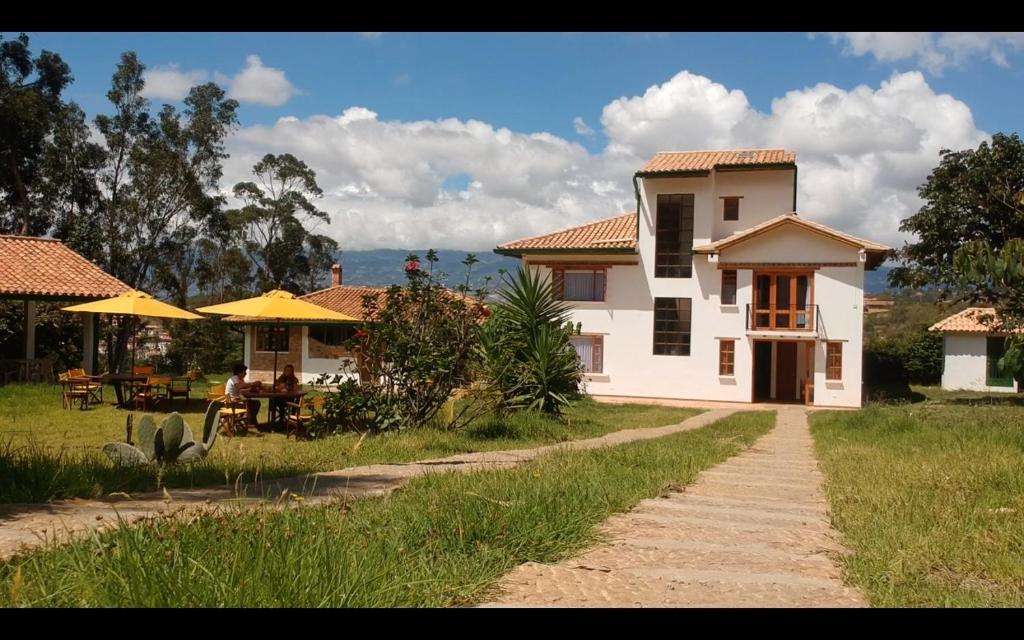 ein weißes Haus mit einem Tisch und Stühlen im Hof in der Unterkunft Casa de Campo Villa Bonita hotel in Villa de Leyva