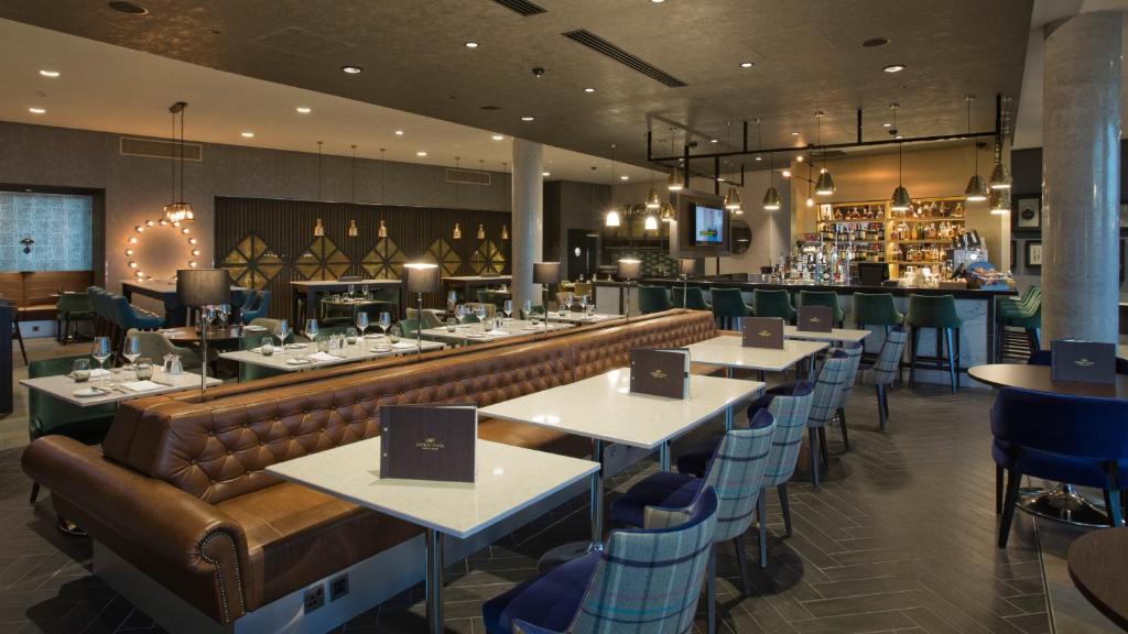 a restaurant with a couch and tables and a bar at Crowne Plaza Aberdeen Airport by IHG in Dyce