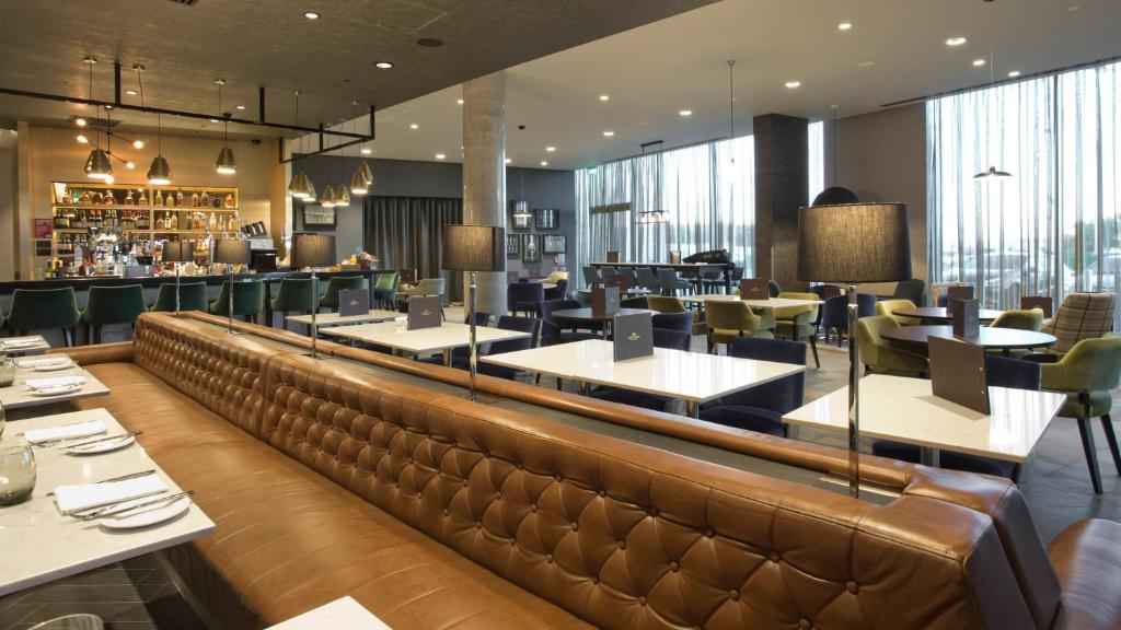 a restaurant with tables and chairs and a bar at Crowne Plaza Aberdeen Airport by IHG in Dyce