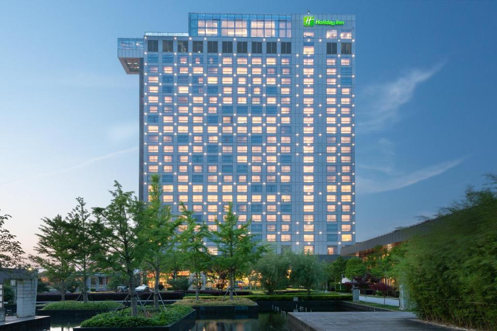 a tall building with a sign on top of it at Holiday Inn Shanghai Pudong Kangqiao, an IHG Hotel in Shanghai