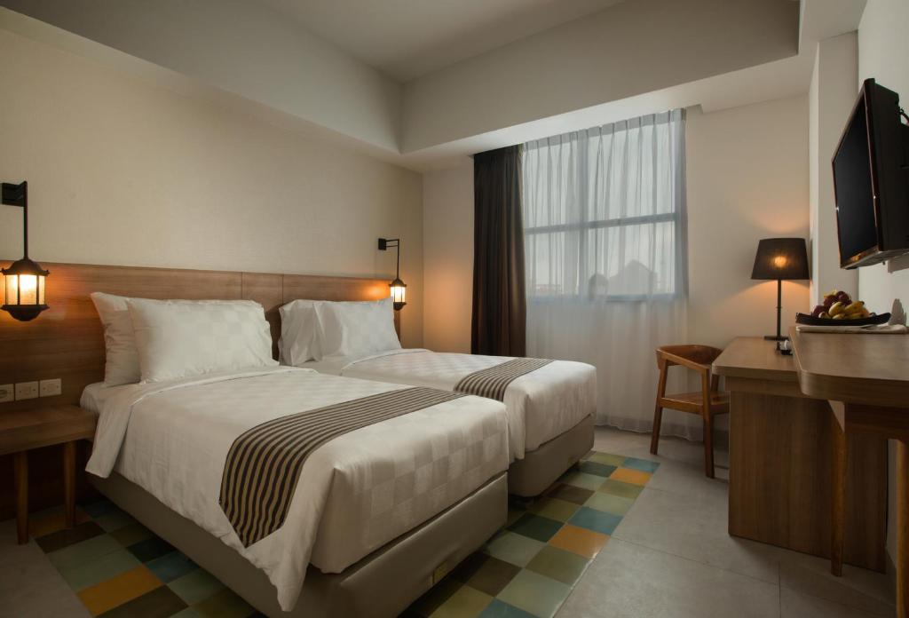 Postel nebo postele na pokoji v ubytování KHAS Tugu Hotel Yogyakarta
