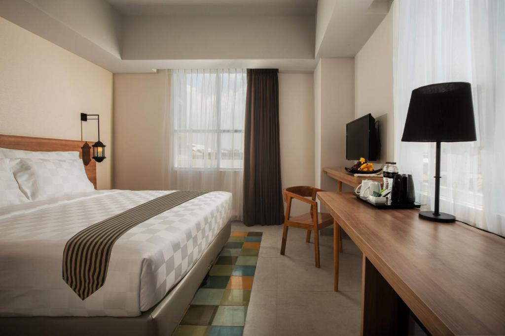 Postel nebo postele na pokoji v ubytování KHAS Tugu Hotel Yogyakarta