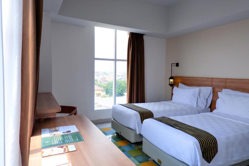 Postel nebo postele na pokoji v ubytování KHAS Tugu Hotel Yogyakarta