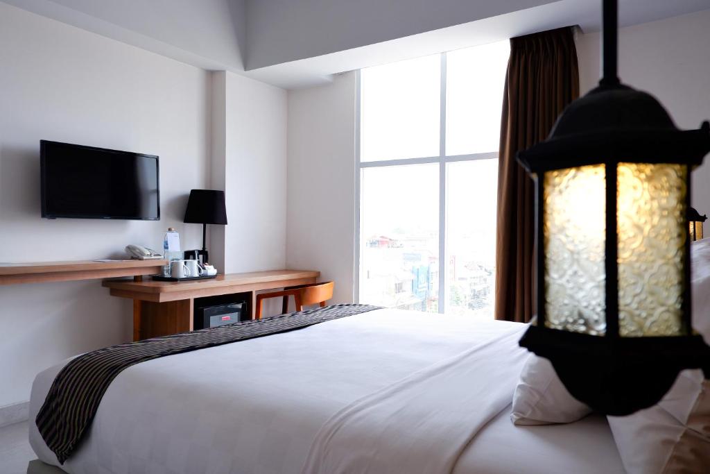 Postel nebo postele na pokoji v ubytování KHAS Tugu Hotel Yogyakarta