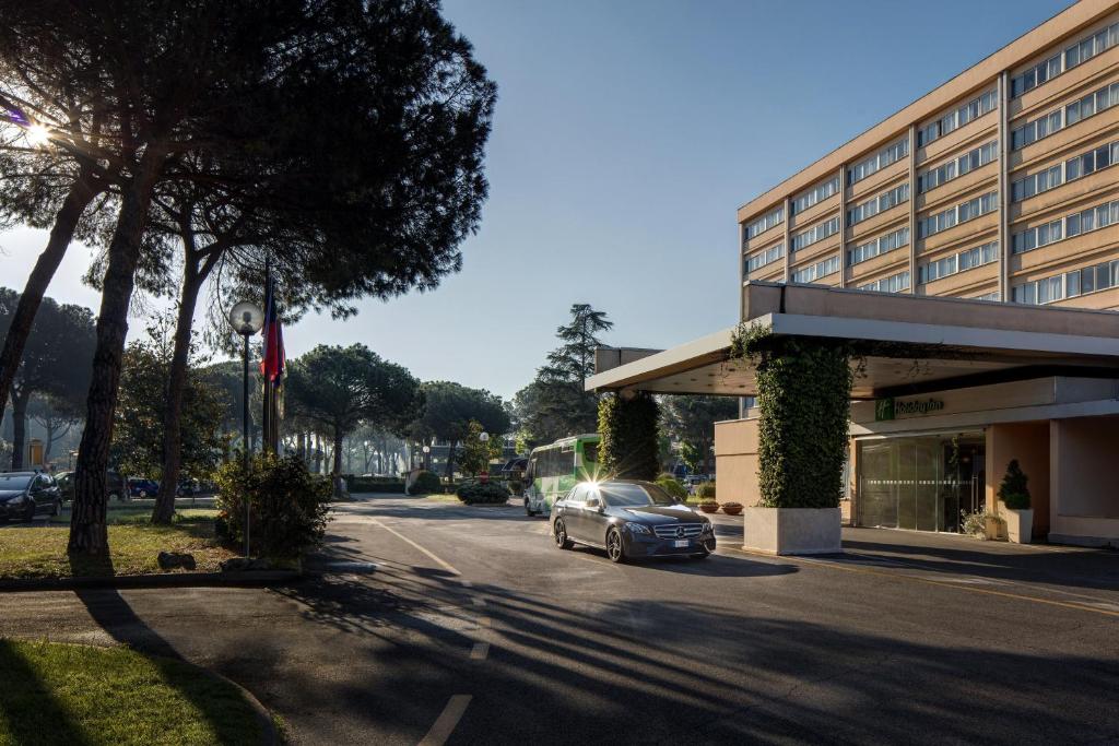 a car parked on a street next to a building at Holiday Inn Rome - Eur Parco Dei Medici, an IHG Hotel in Rome