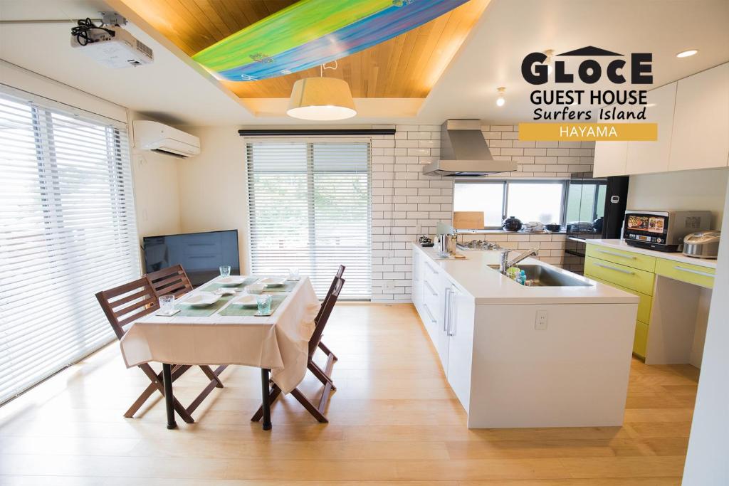 cocina y comedor con mesa y sillas en GLOCE 葉山 サーファーズログハウス l HAYAMA Surfers Log house en Hayama
