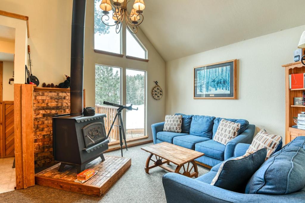 a living room with a blue couch and a stove at The Chamberlain Chalet in Angel Fire