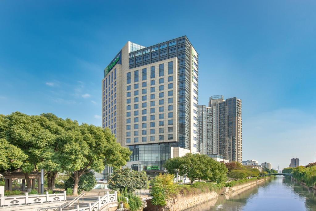 una rappresentazione di un edificio alto accanto a un fiume di Holiday Inn Taicang City Centre, an IHG Hotel a Taicang