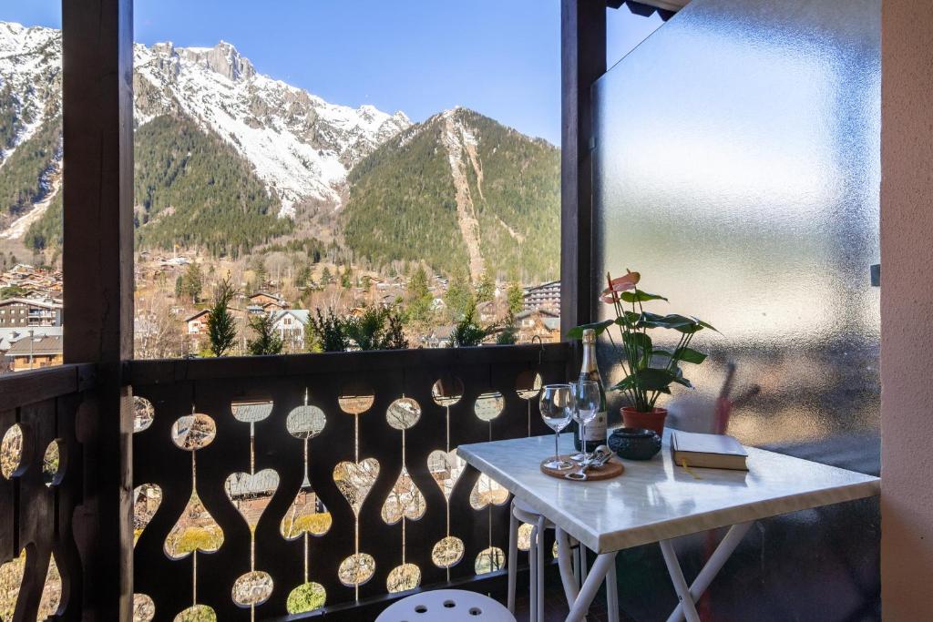 d'un balcon avec une table et une vue sur les montagnes. dans l'établissement Rivière 407 - Happy Rentals, à Chamonix-Mont-Blanc