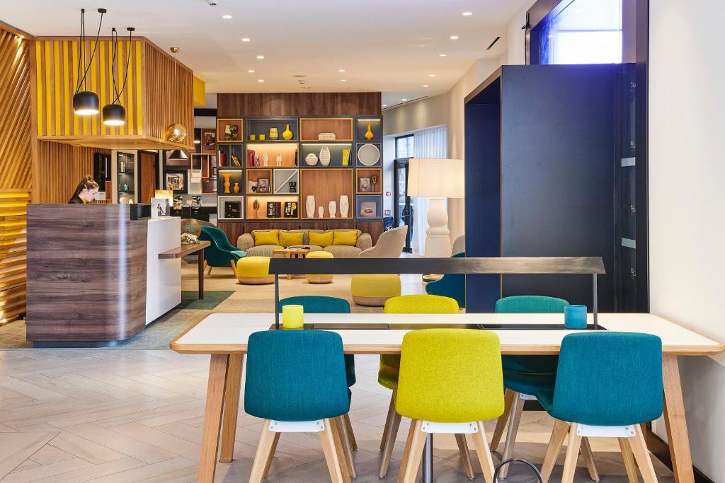 a kitchen with a table, chairs and a refrigerator at Holiday Inn Nice, an IHG Hotel in Nice