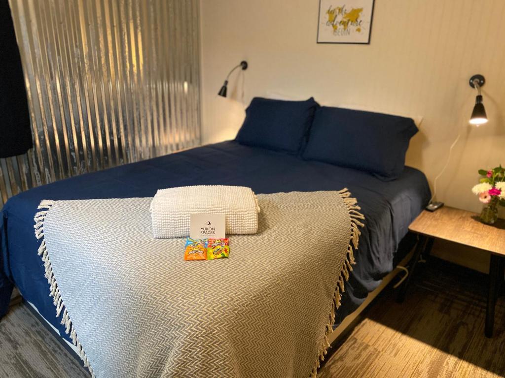 um quarto com uma cama azul com duas caixas em Dawson Lodge em Dawson City