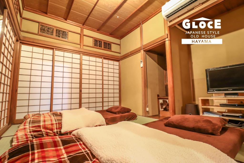 a japanese living room with a tv at GLOCE 葉山 囲炉裏付古民家ゲストハウス l HAYAMA Old Folk House with Sunken Hearth in Hayama